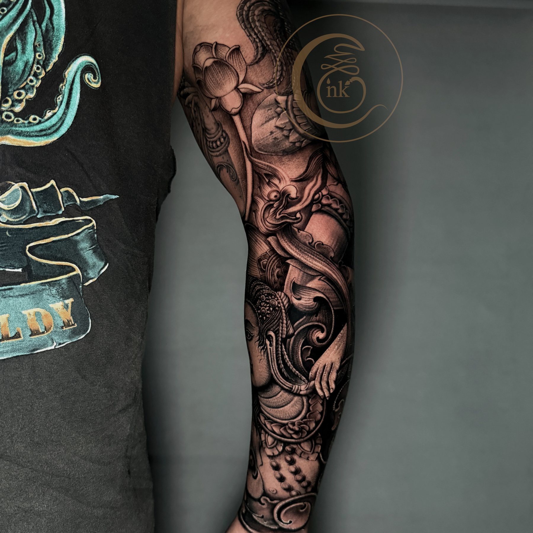 Black and gray realism sleeve detail — naga and lotus ornament