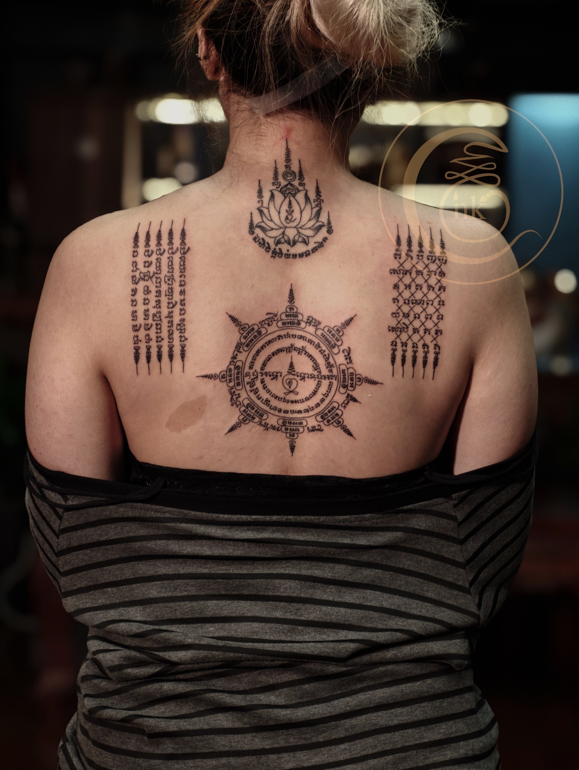 Tattoo artist with the completed set of Sak Yant tattoos