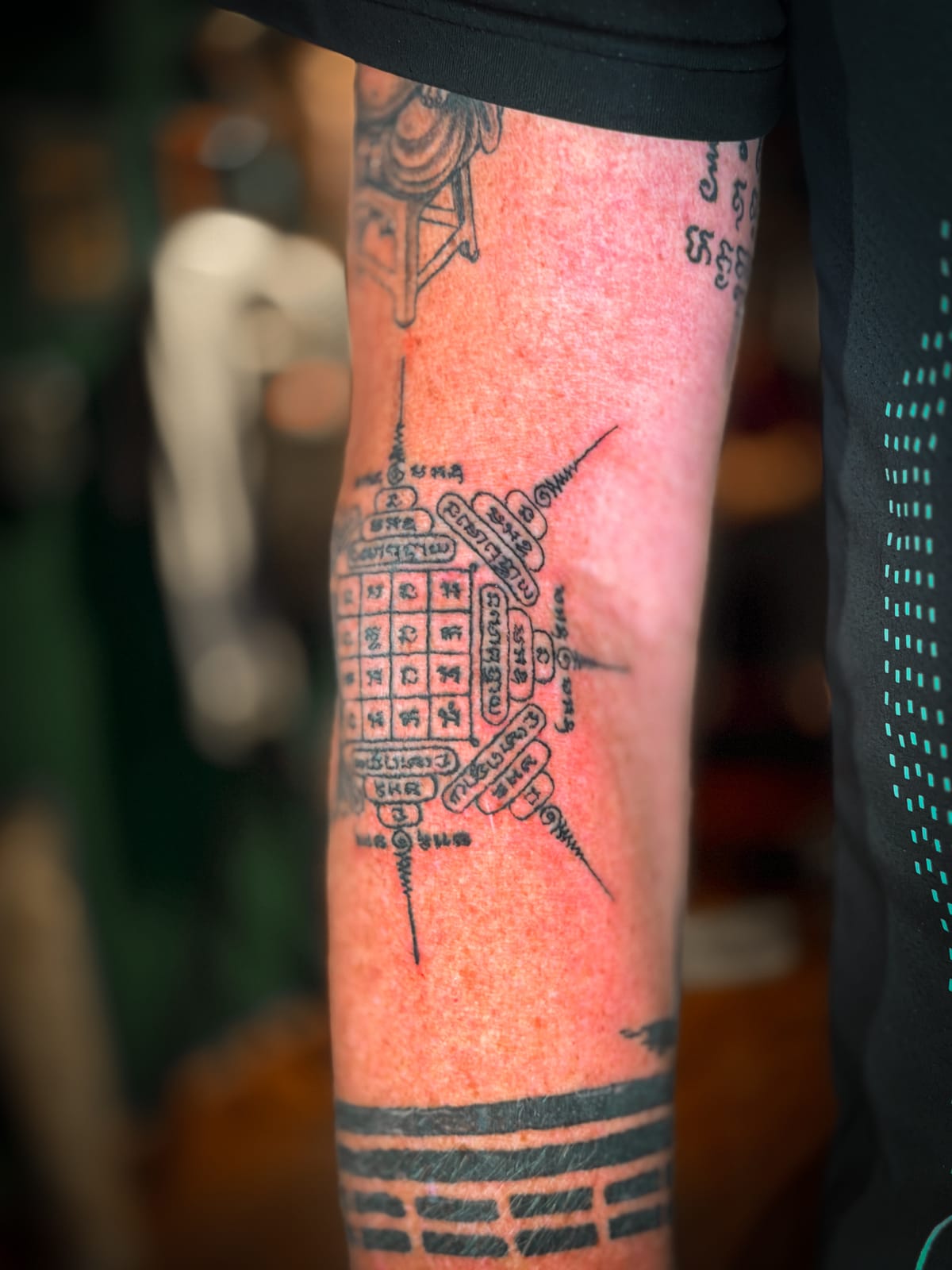 Side view of a Khmer yantra tattoo with protective symbols.