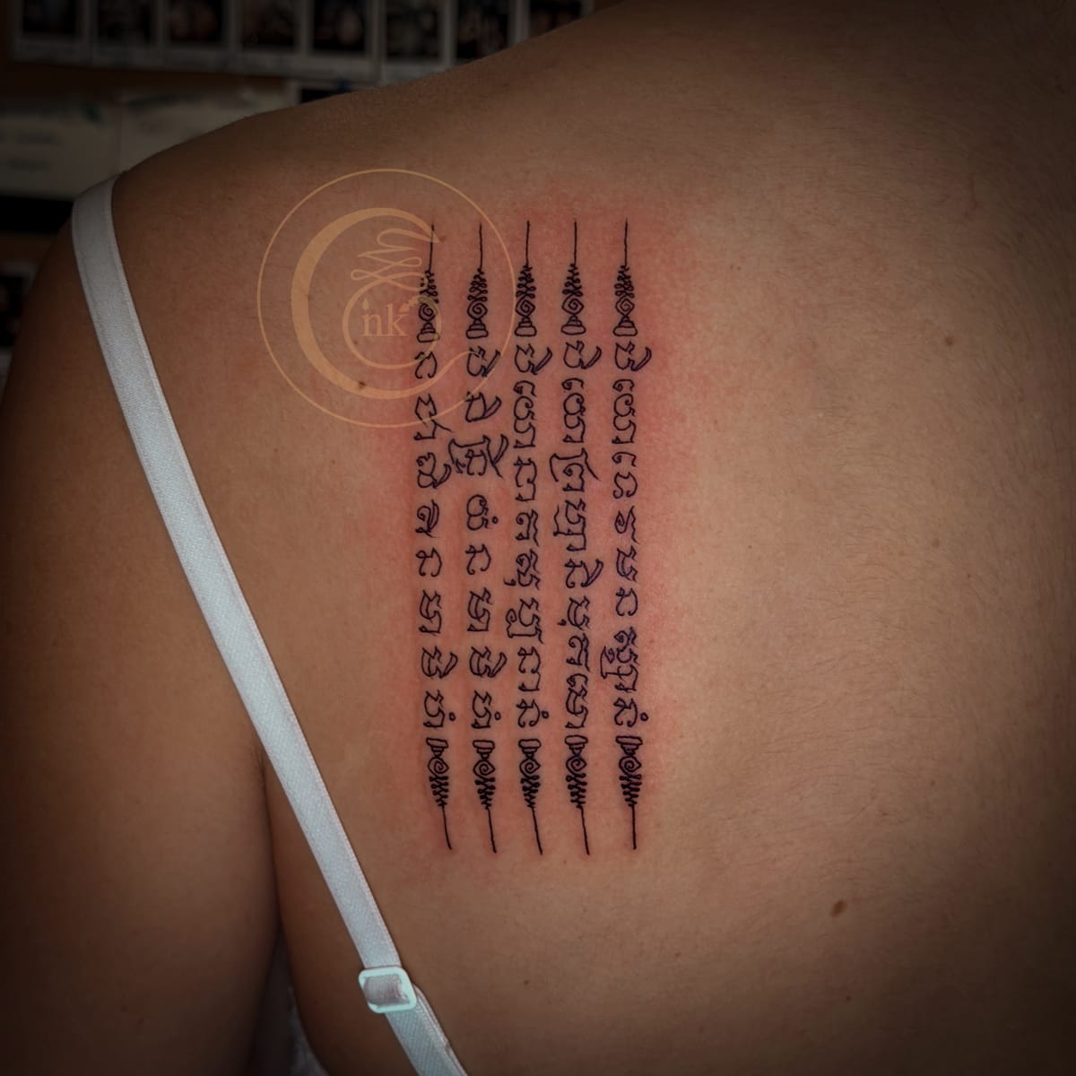 A five-row yantra tattoo shown on the upper back.