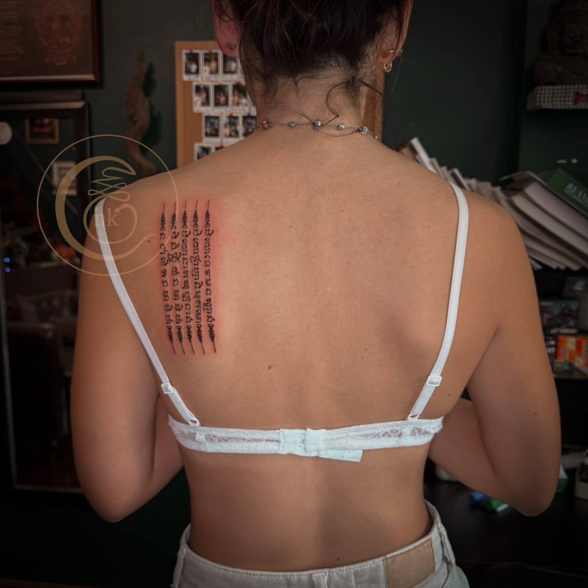 Client showing a completed five-row Khmer yantra tattoo.